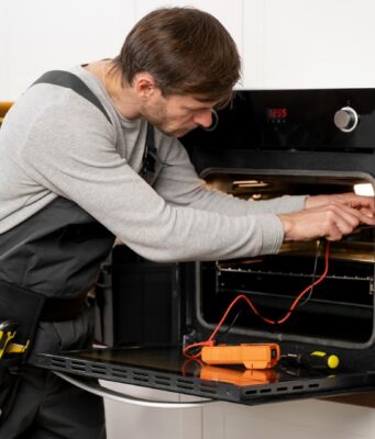 men repair oven