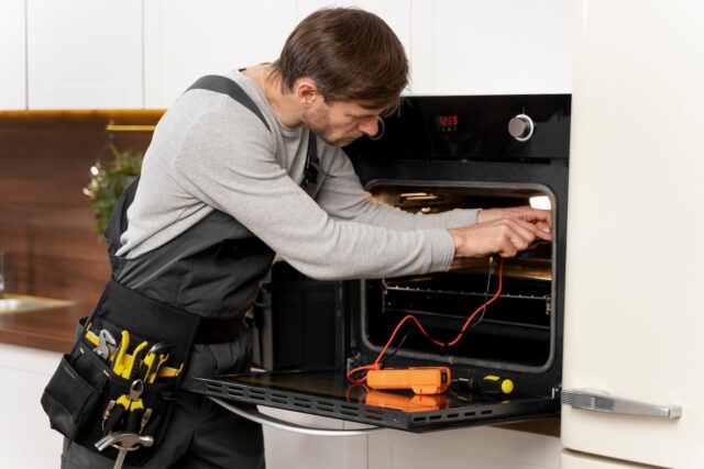 men repair oven